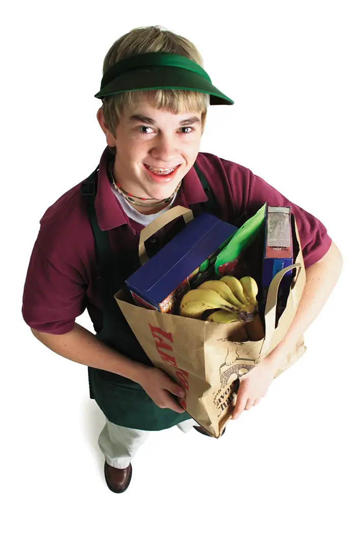 Image of a young man holding a bag of groceries