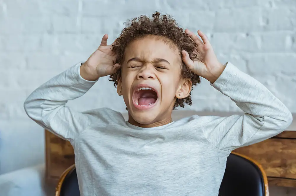 Upset boy with his hands at his head